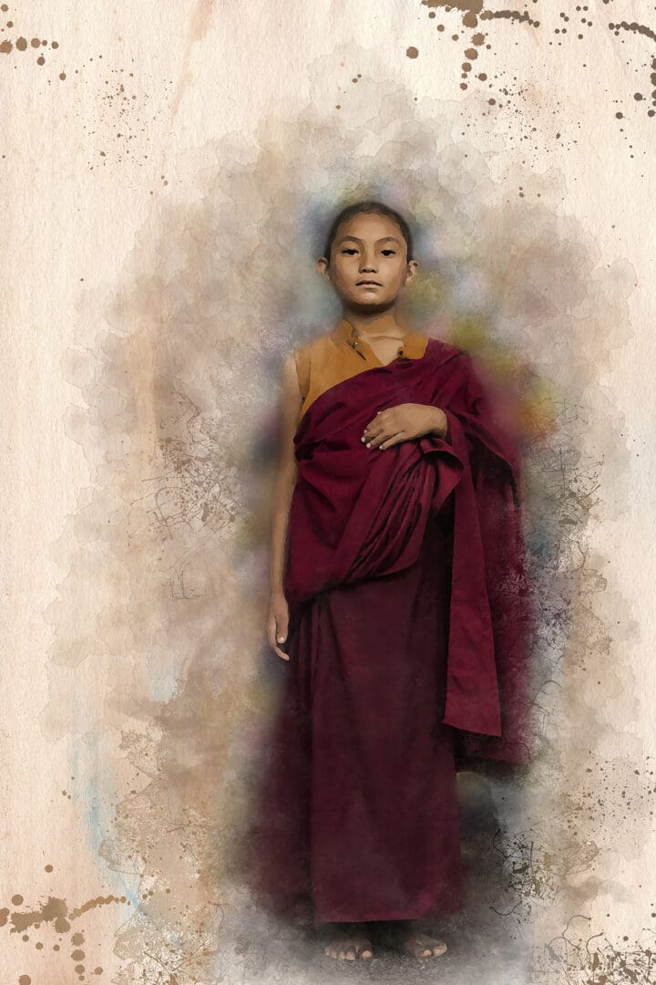 A young monk in red robes standing next to a wall.