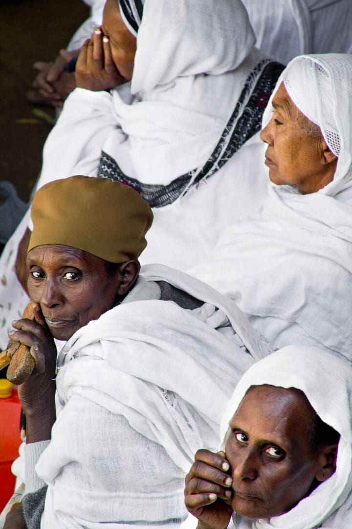 A group of people sitting in white robes.