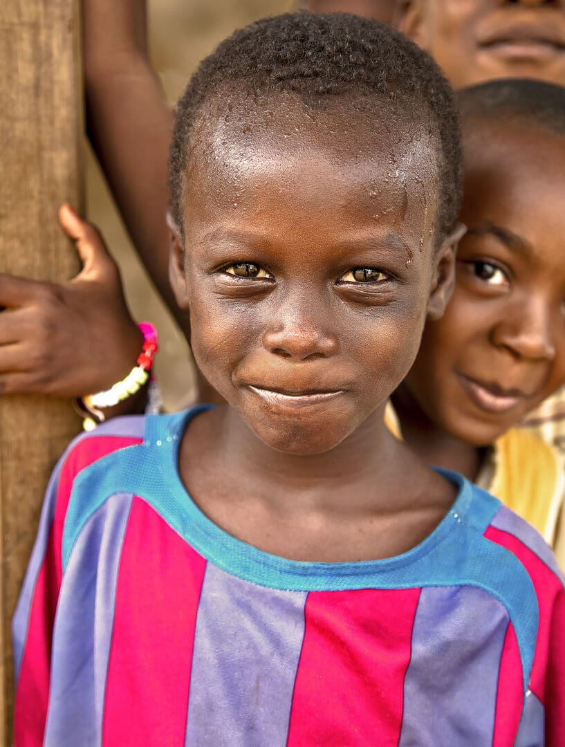 Two children are standing together and smiling.