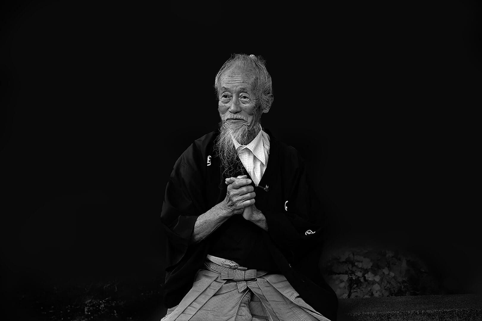 A man sitting down with his hands clasped.