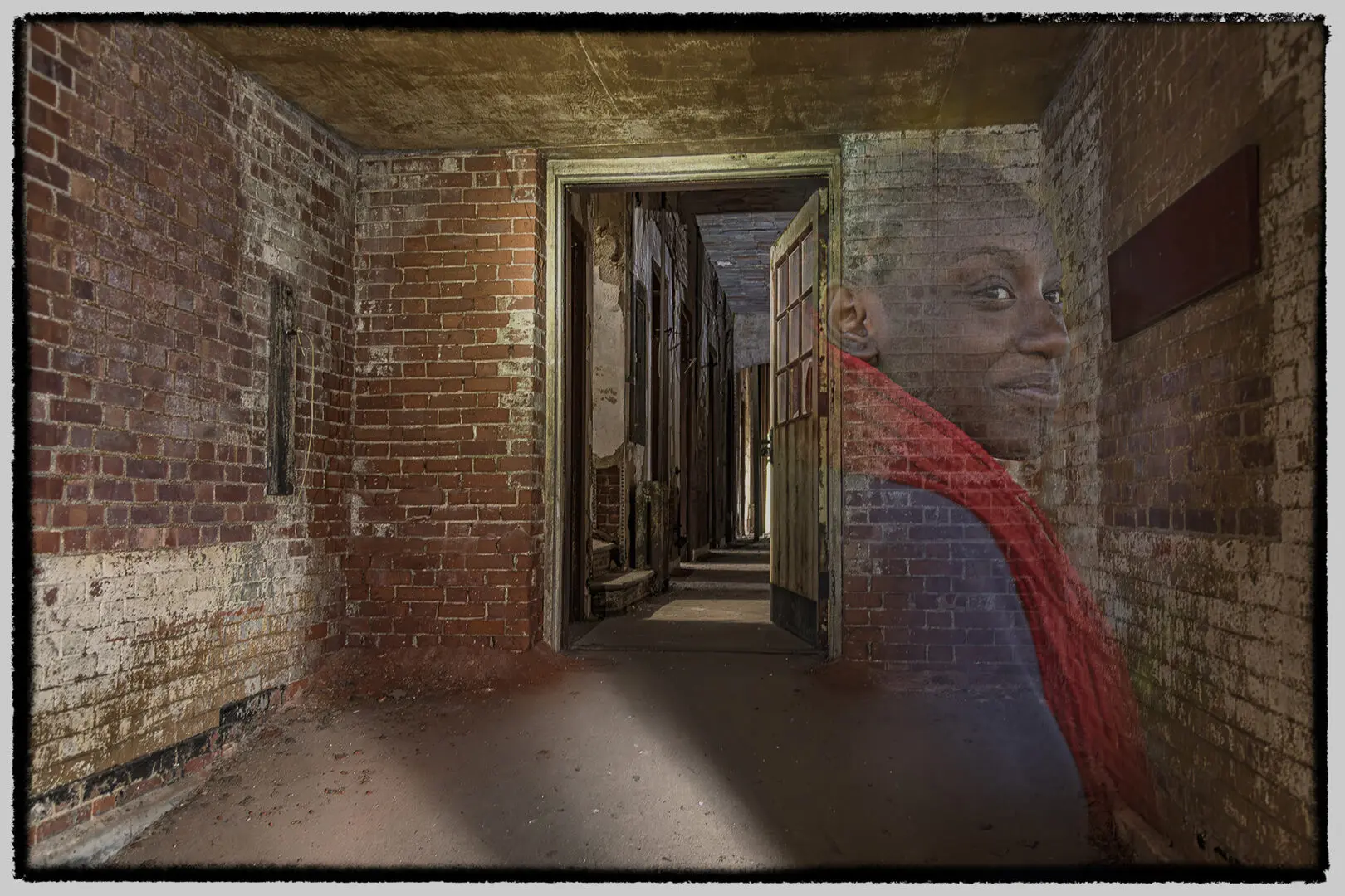 A hallway with brick walls and graffiti on the wall.