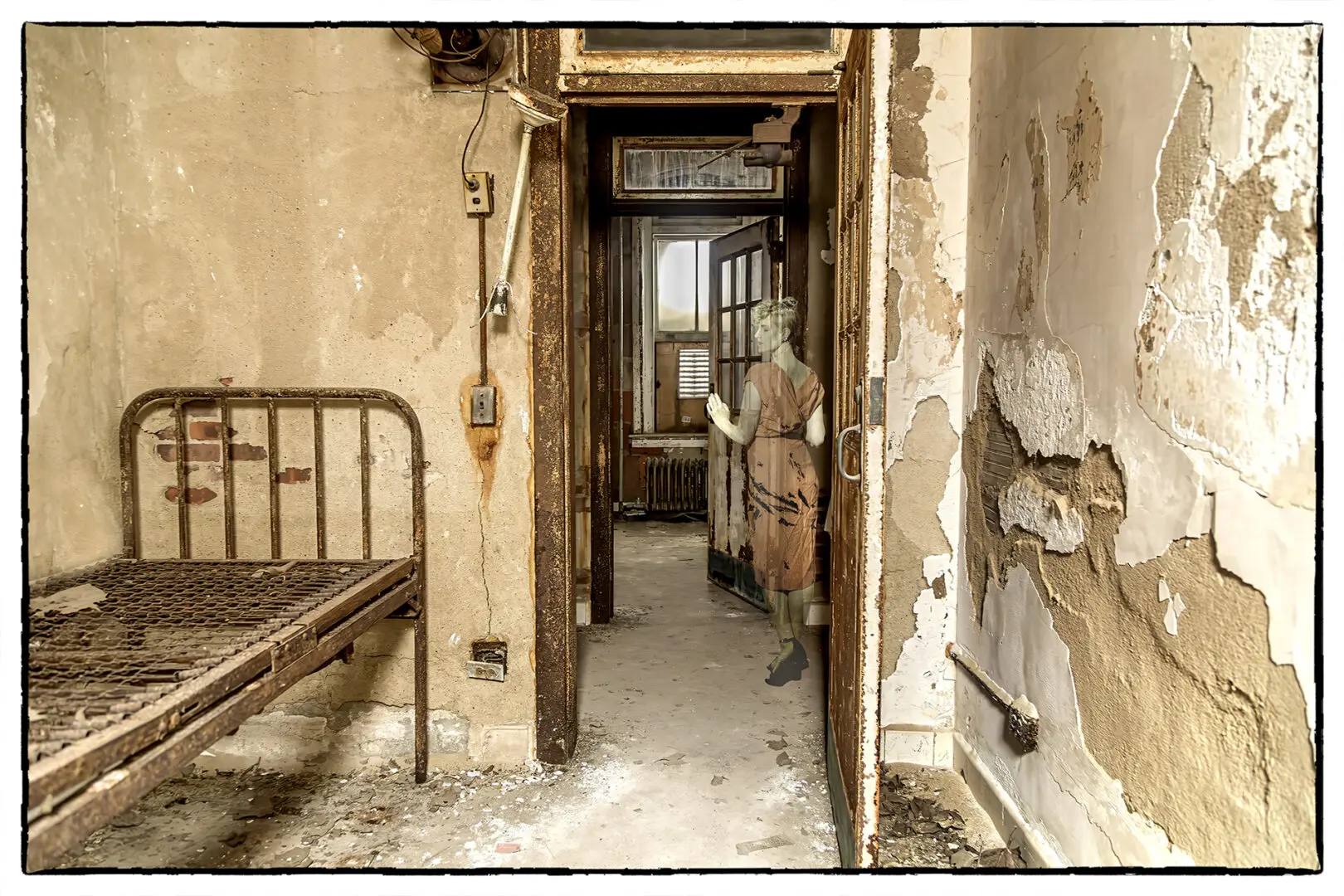 A room with an old bed and a door.