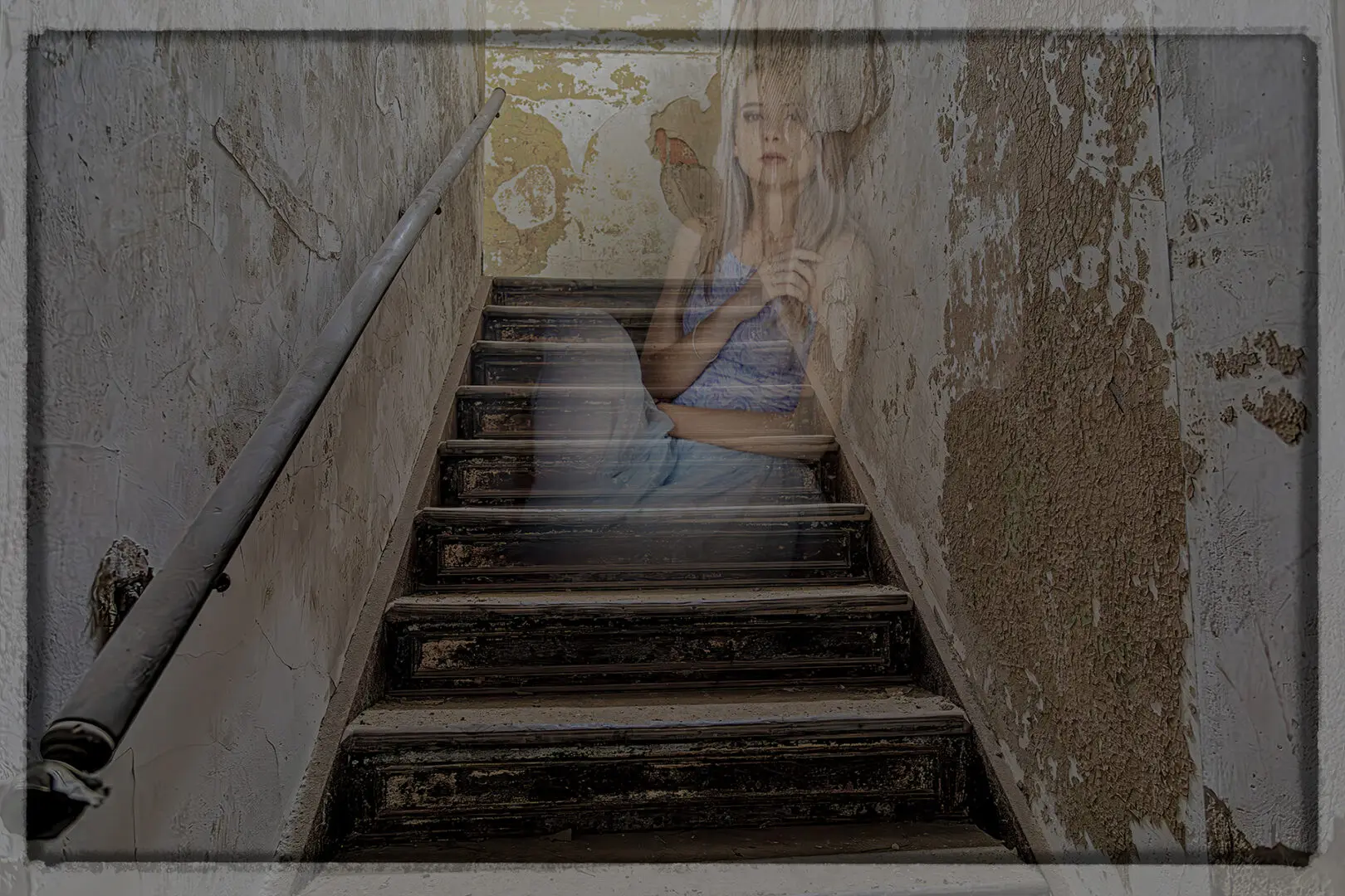 A woman sitting on the bottom of stairs.