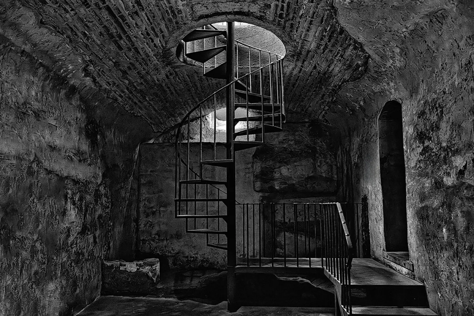 A black and white photo of an old building with stairs.