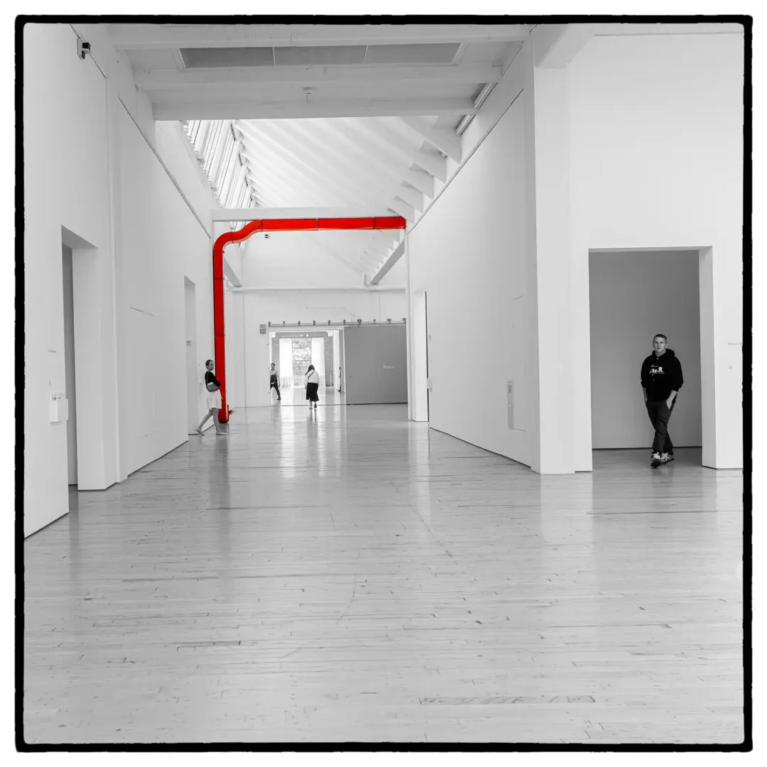 A red pole in the middle of an empty room.