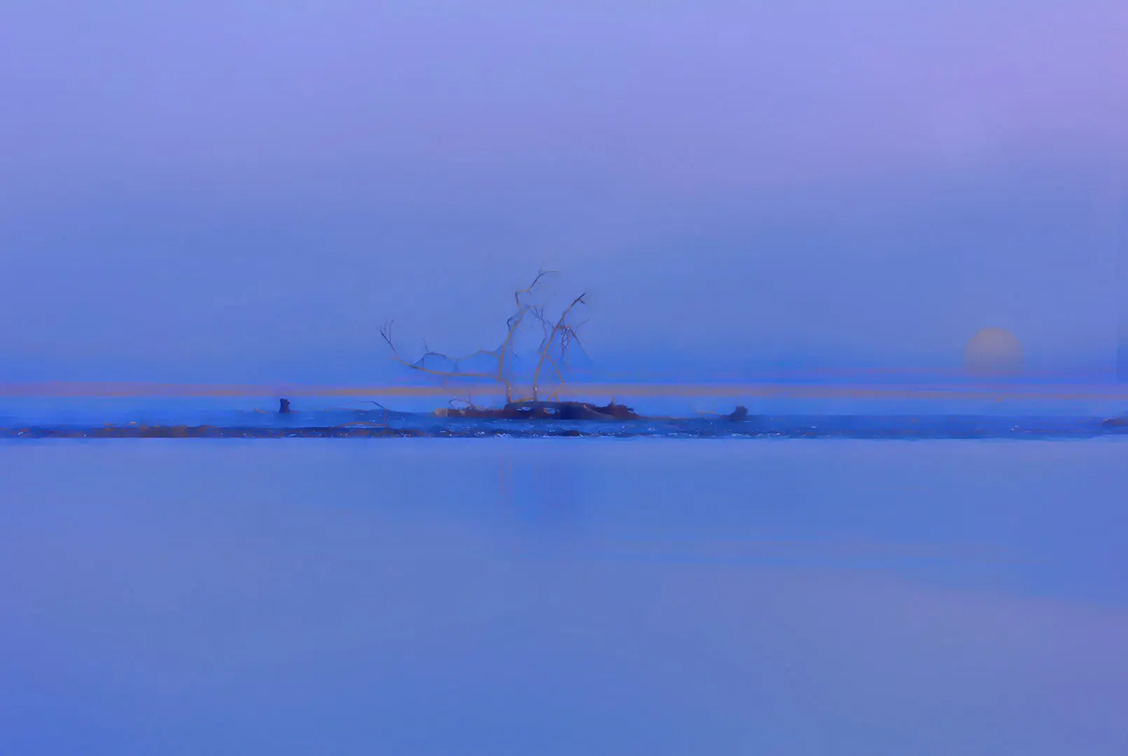 A large body of water with a boat in the distance.