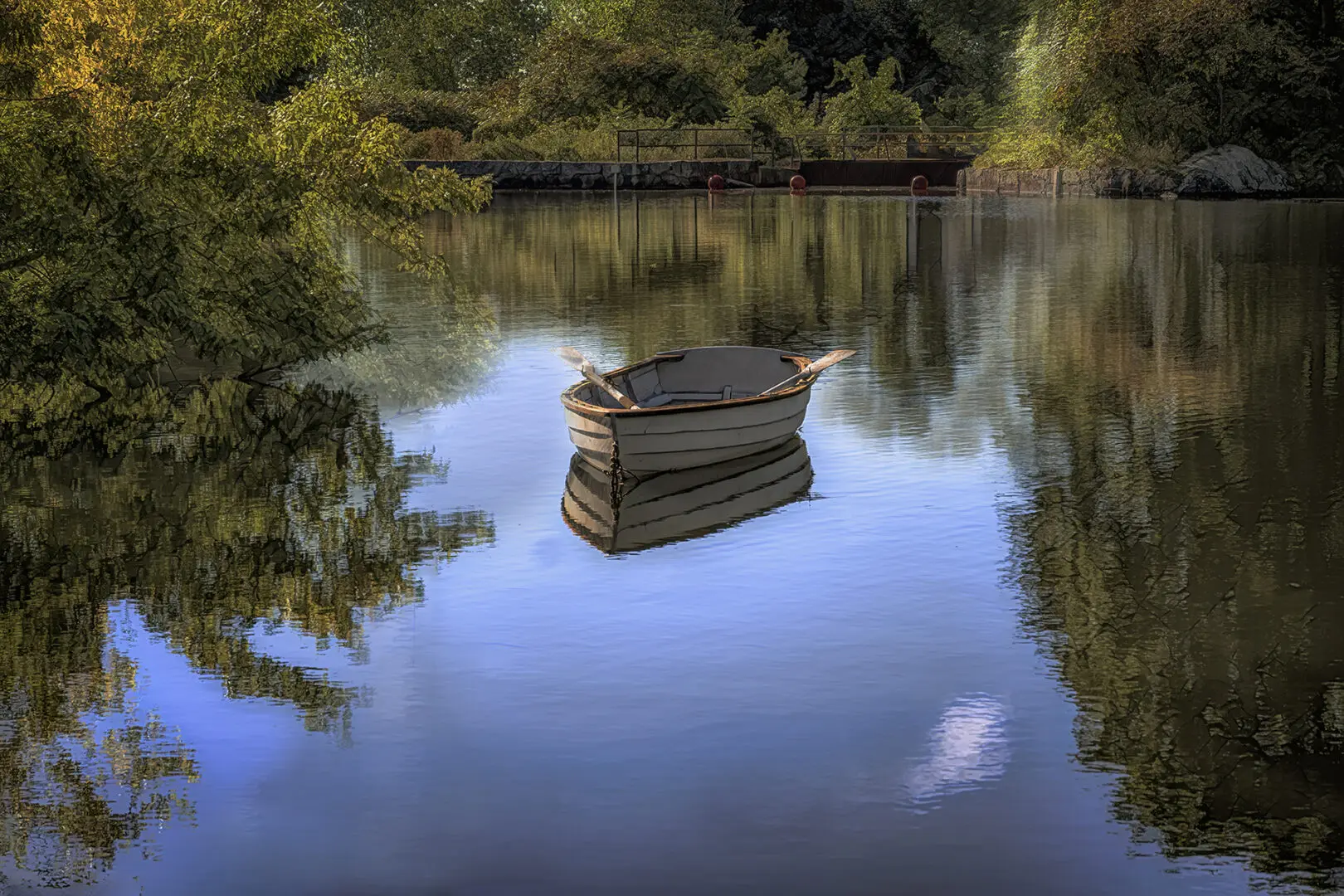 A boat floating on top of a lake near trees.