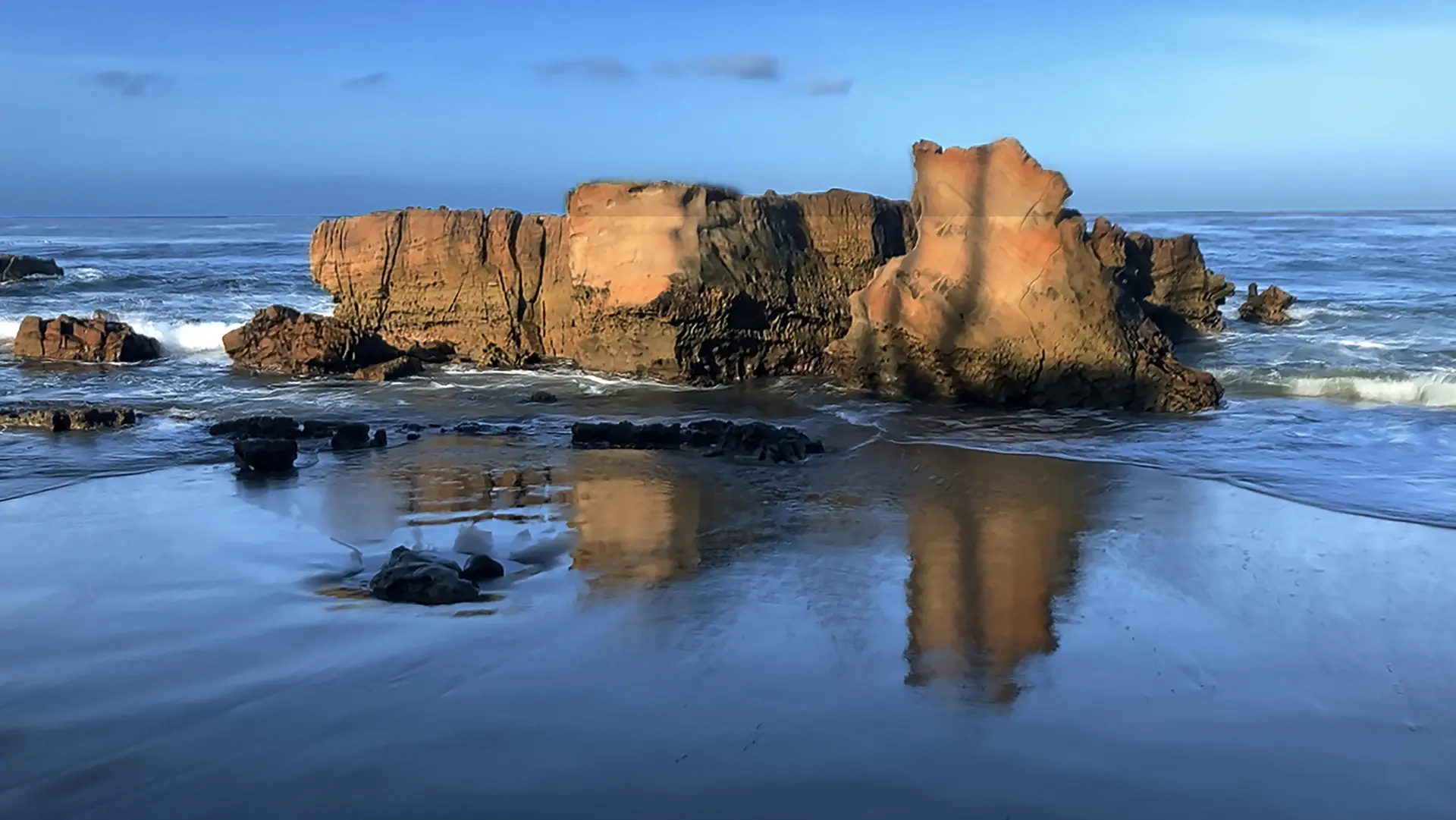 A body of water with rocks in the background