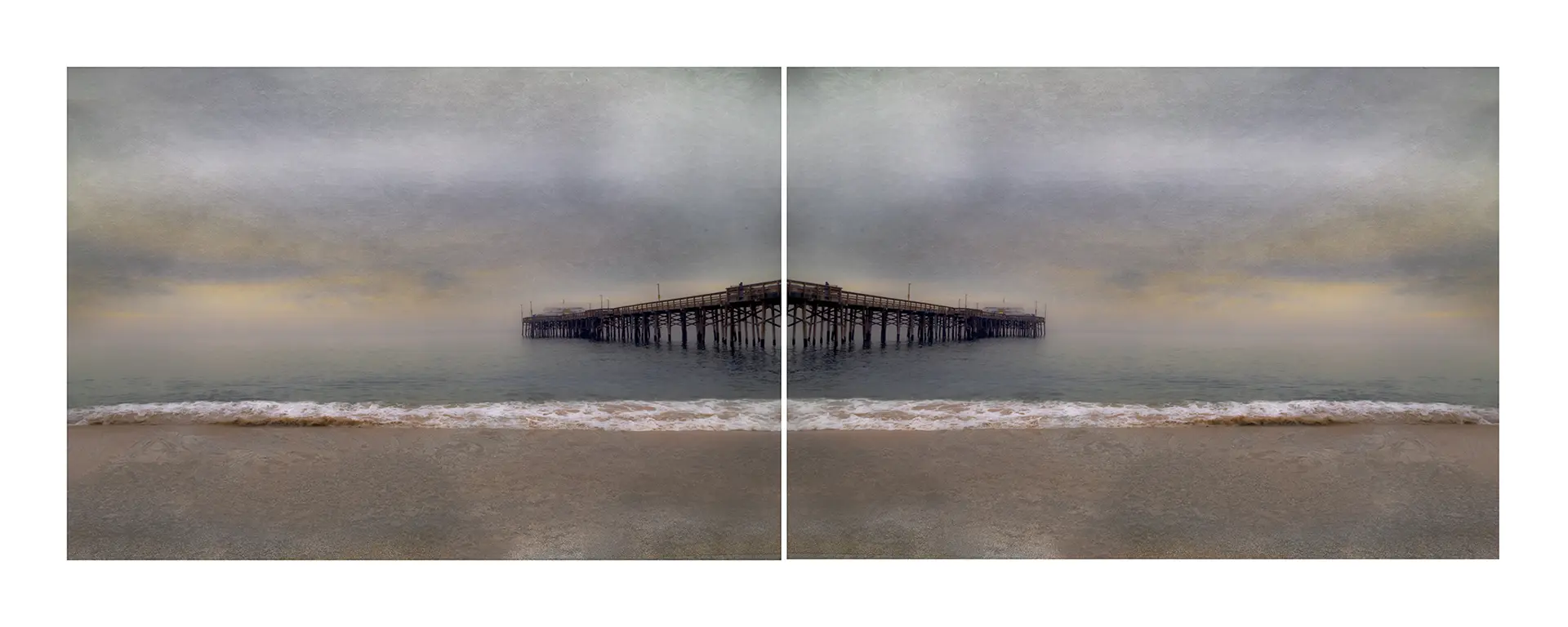 A large pier on the beach with water in front of it.