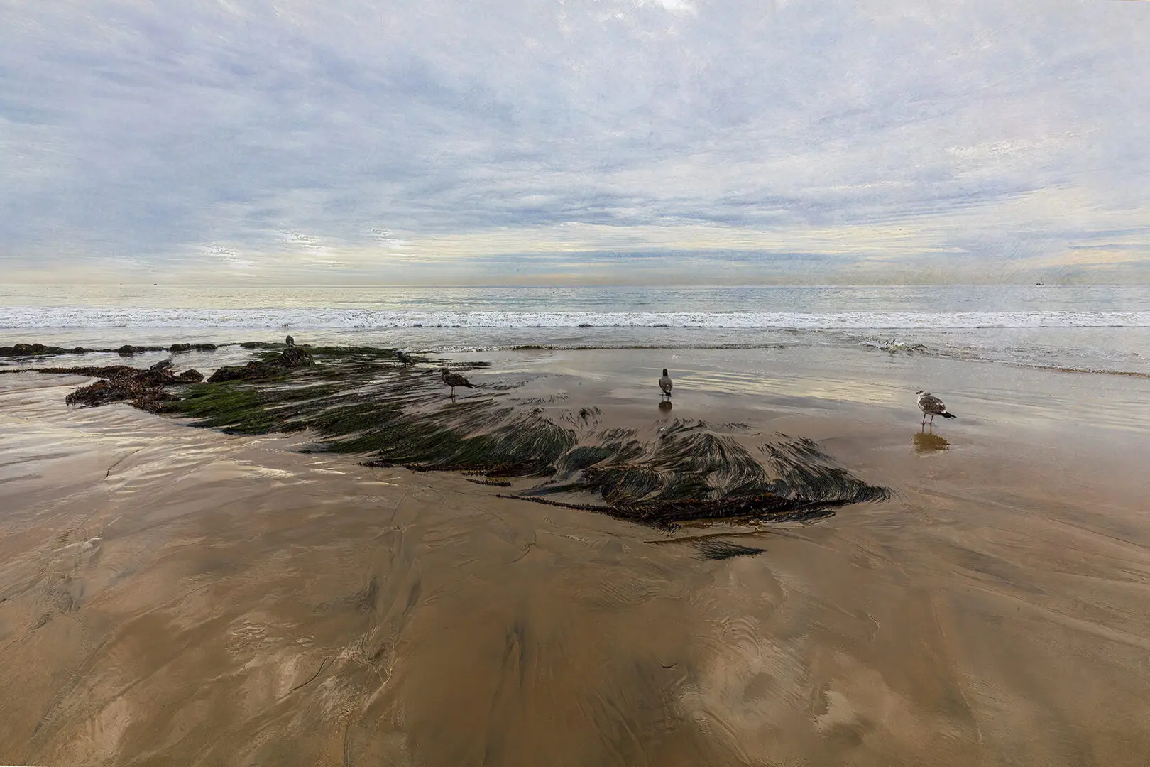 A person standing on top of rocks in the sand.