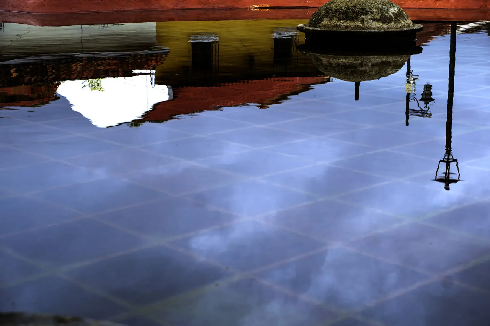 A reflection of clouds in the water on the ground.