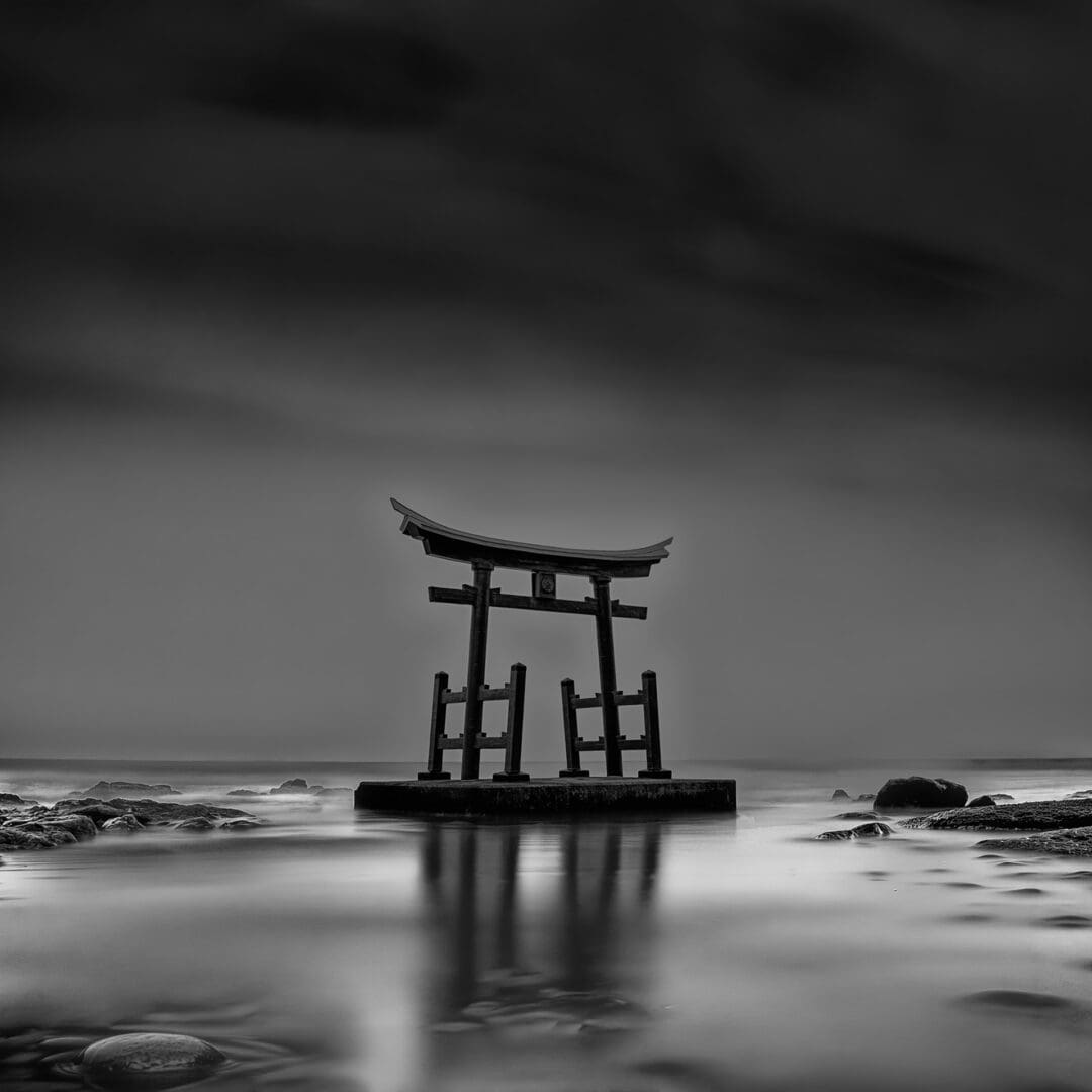 Torii gate standing on platform in sea