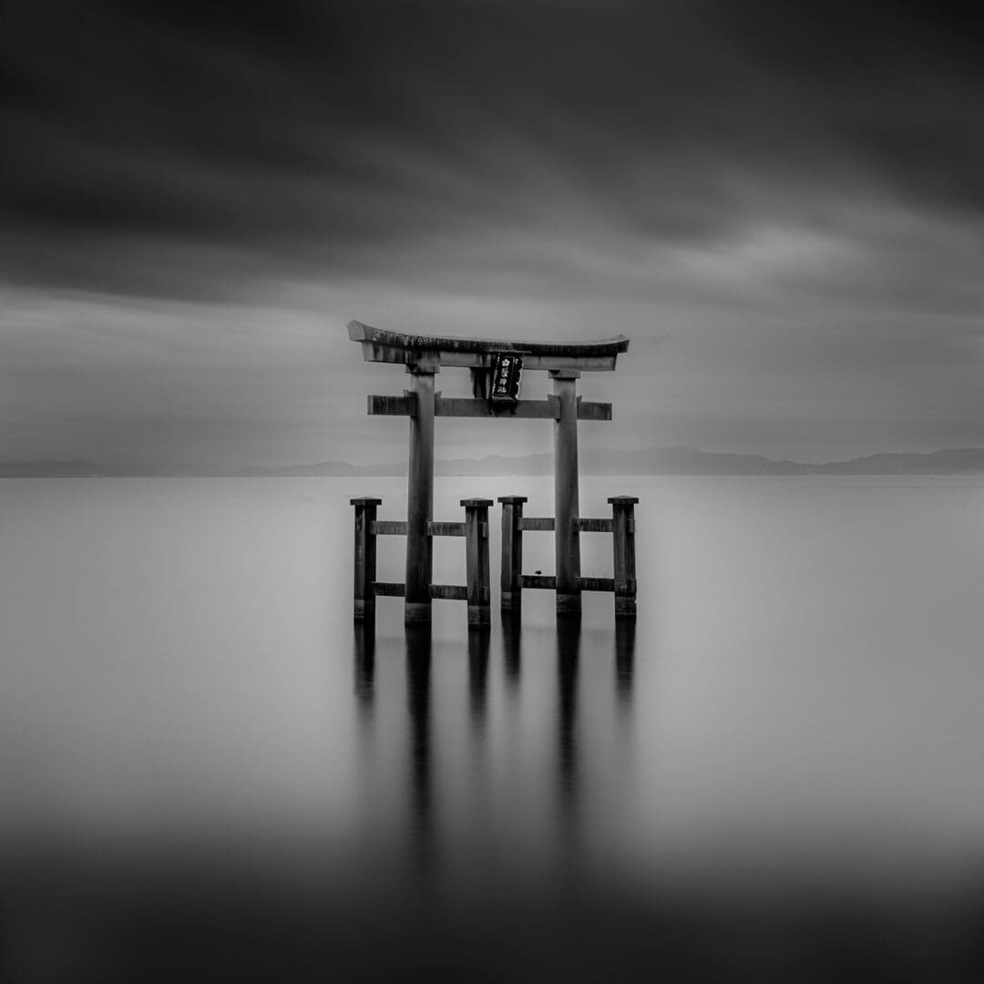 Torii gate in calm misty water