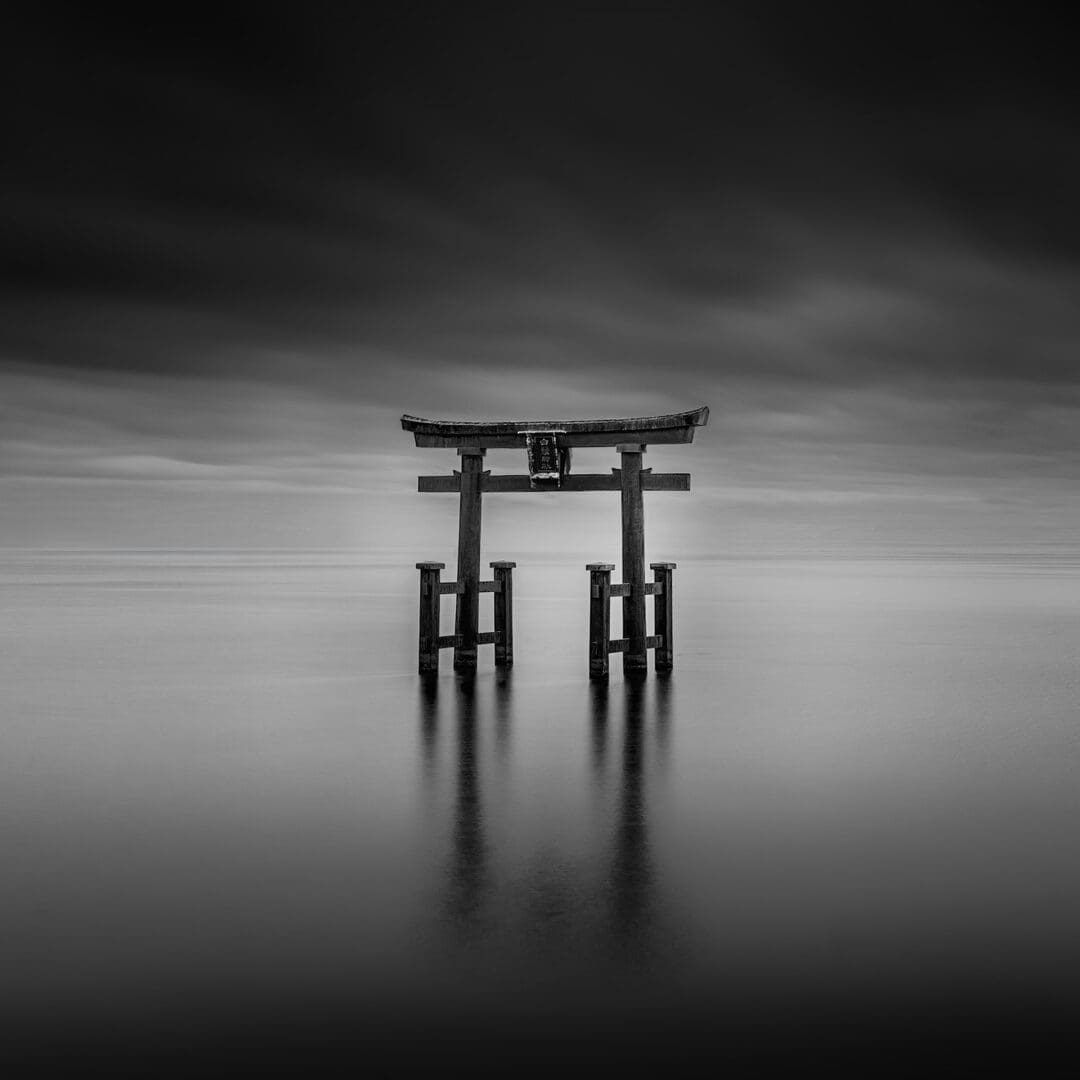 Torii gate standing in calm water reflection